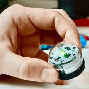 Ein Ozobot wird mit einer Hand festgehalten