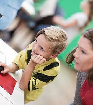 Junge und Trainerin vor Laptop