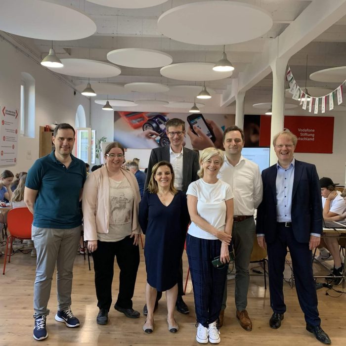 Eine Gruppe von sieben Personen steht im Hub für digitale Bildung in Düsseldorf. Darunter Vertreter spanischer Lehrkräfte sowie der Vodafone Stiftung.