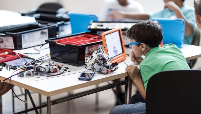 junge-mit-roboter Ein Junge sitzt vor einem Tablet.