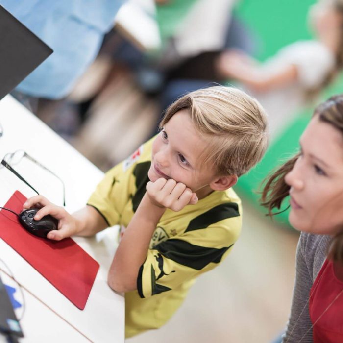 junge und trainerin vor laptop