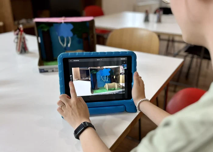 Tablet in der Hand einer Person zeigt eine Stop Motion Scene